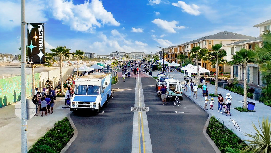 Festival street at Hoʻopili lined with food trucks, tents, and palm trees
