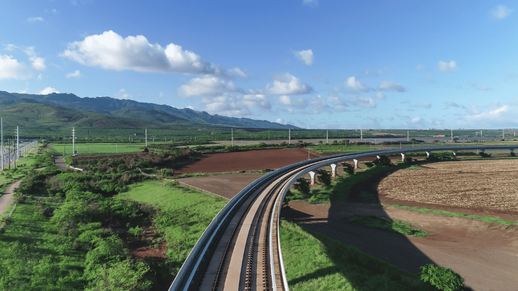 Skyline rail guideway curving through Hoʻopili farm fields
